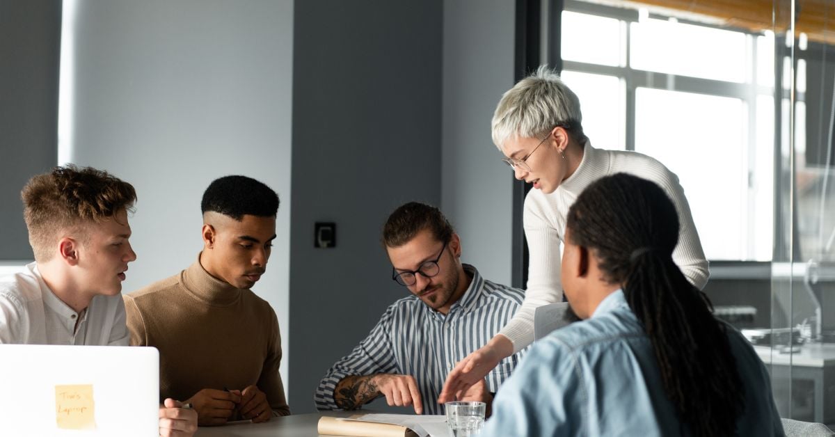 group of men and women in office meeting